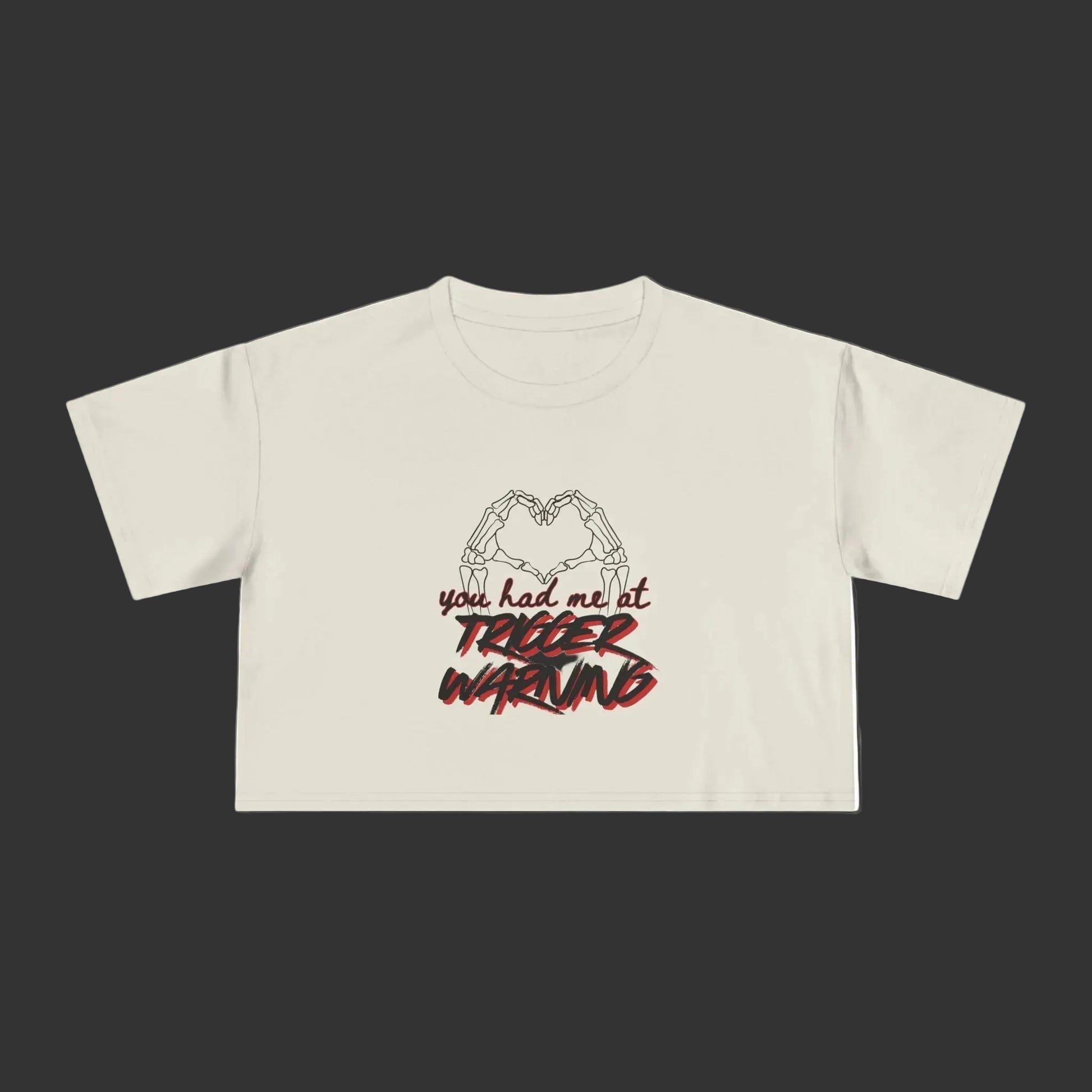 Bone crop top with graphic design and text on a grey background