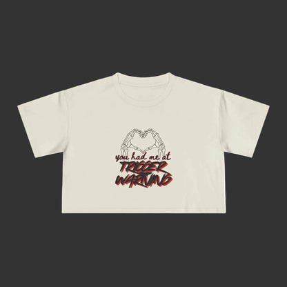 Bone crop top with graphic design and text on a grey background